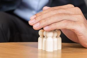 Businessman hand cover man wooden from crowd of employees. People, Business, Human resource management, Life Insurance, Teamwork and leadership Concepts photo