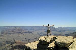 joven frente al paisaje del gran cañón - sensación de libertad, éxito foto