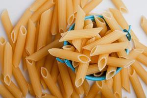 raw macaroni in blue bucket on white background.top view photo