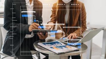 Project manager working and update tasks with milestones progress planning and Gantt chart scheduling diagram. business working with smart phone, tablet and laptop in office. photo