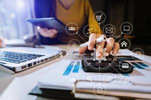 Hands using mobile phone in modern office with laptop photo