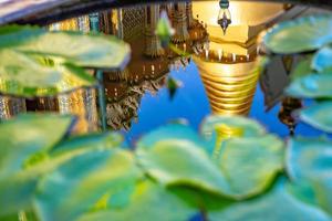 reflejo de una hermosa pagoda en un estanque de loto foto