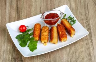 Cheese sticks on the plate and wooden background photo