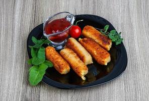 Cheese sticks on the plate and wooden background photo