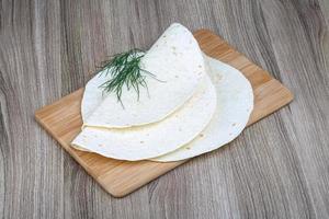 tortillas en plato de madera y fondo de madera foto