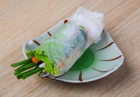 Spring rolls on the plate and wooden background photo