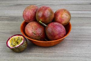 Fresh tropical fruit - Maracuja in a bowl on wooden background photo