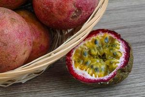 Fresh tropical fruit - Maracuja in a basket on wooden background photo