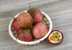 Fresh tropical fruit - Maracuja in a basket on wooden background photo