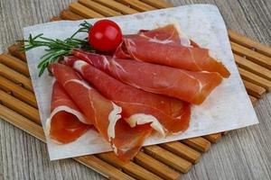 Jamon on wooden plate and wooden background photo