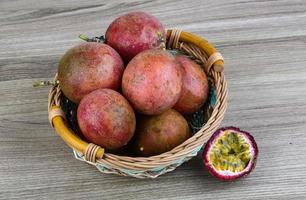 Fresh tropical fruit - Maracuja in a basket on wooden background photo