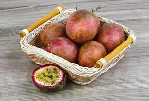 Fresh tropical fruit - Maracuja in a basket on wooden background photo