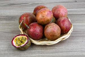 Fresh tropical fruit - Maracuja in a basket on wooden background photo