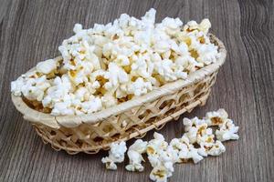 Popcorn in a bowl on wooden background photo