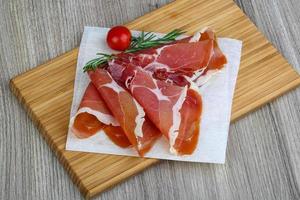 Jamon on wooden plate and wooden background photo