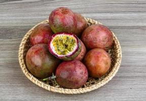 Fresh tropical fruit - Maracuja in a basket on wooden background photo