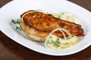 Grilled pork on the plate and wooden background photo