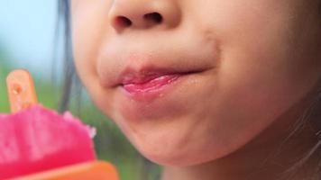 bambina sveglia che mangia un gelato all'aperto. video