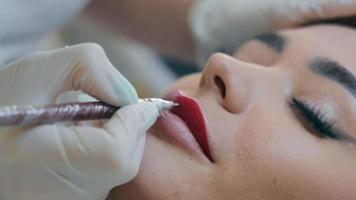 Permanent Make-up und Korrektur der Lippenform und Lippenkontur. Maskenbildner malt Lippen. video