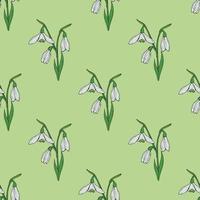 Seamless background with lovely snowdrops on light green background. Endless vector flowers pattern for your design.