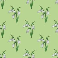 Seamless background with lovely snowdrops on light green background. Endless vector flowers pattern for your design.