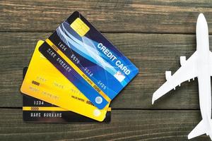 Credit card and airplane model on wooden desk photo