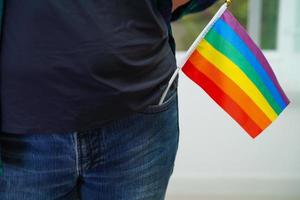 mujer asiática con bandera del arco iris, derechos de símbolos lgbt e igualdad de género, mes del orgullo lgbt en junio. foto