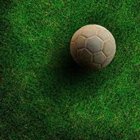 Old ball on green grass soccer field. photo