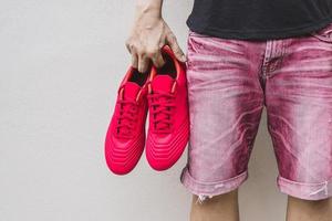 Man holding football boots in his hand. photo