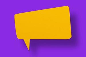 Speech balloon shaped yellow paper against a purple background. photo