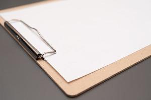 a clipboard with a white sheet of paper photo