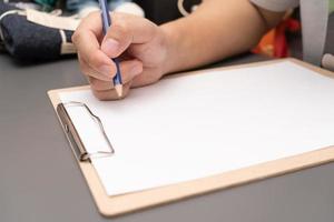 hand writing on clipboard. Stationery. write a note on empty blank with a pencil photo