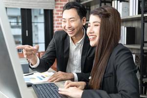 businessman showing something to colleague on desktop computer in office photo