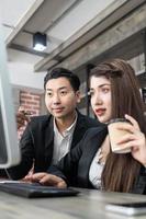 businessman showing something to colleague on desktop computer in office. Business man and woman working together photo