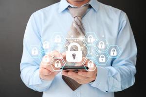 Businessman holds a padlock that protects company and information data via a virtual network connection. Innovation technology creates clever solutions to protect against digital attacks. photo