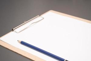 a clipboard with a white sheet of paper photo