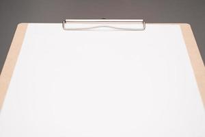 selective focus. a clipboard with a white sheet of paper photo