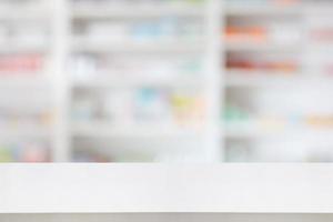 Pharmacy drugstore counter table with blur abstract backbround with medicine and healthcare product on shelves photo