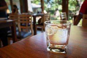 vaso de agua en la mesa de madera en el restaurante foto