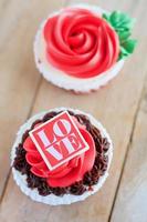 pastelitos de rosas rojas en la mesa de madera foto