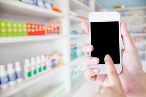 women using smartphone in the pharmacy blurred background photo