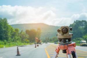 Surveyor equipment tacheometer or theodolite with road construction site background photo