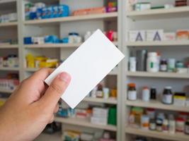 primer plano de la mano del farmacéutico paquete de caja de medicina foto