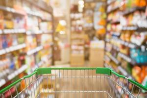 Shopping cart with Abstract Supermarket aisle blur background photo