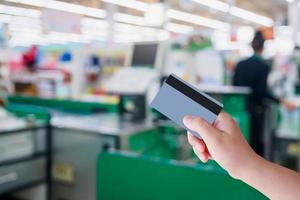 paying using credit card at supermarket checkout cashier photo