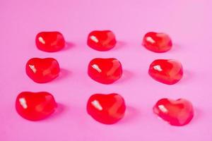 red valentine candy hearts shape on pink background photo