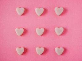 forma de corazones de caramelo de san valentín sobre fondo rosa foto