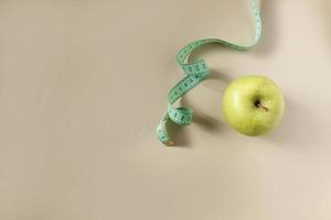 Diet concept. Apple with measuring tape photo