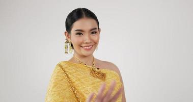 retrato de mulher tailandesa em traje tradicional está dançando. fêmea olhando para a câmera e sorrindo com fundo branco isolado. video