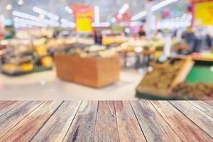 Supermarket with fresh fruits and vegetable on shelves in store blurred background photo